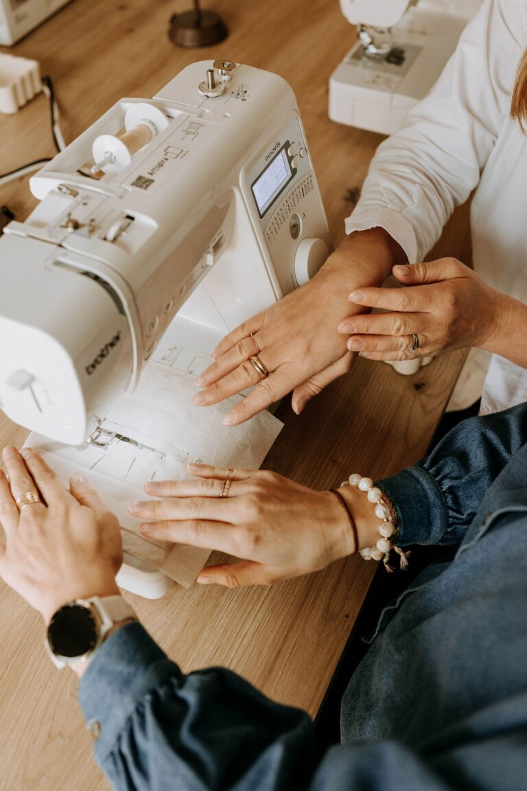 Travail à la machine à coudre sur un tissu blanc, à quatre mains