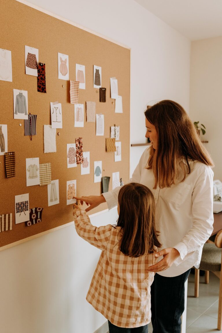 Une femme et une enfant devant le tableau de dessins et d'échantillons de tissus